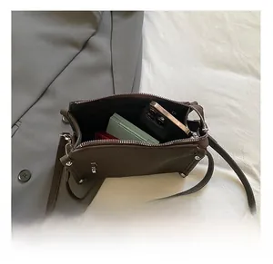 Internal view of dark brown leather handbag showing space for smartphone and makeup