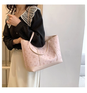 Detail view of pink tote bag featuring cartoon rabbit pattern and dual shoulder straps
