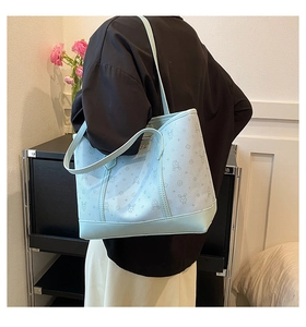 Detail of mint green tote bag featuring cartoon rabbit prints and long shoulder straps