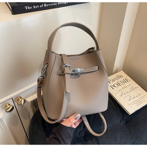 Detail shot of taupe leather bucket bag with silver twist lock and adjustable shoulder strap
