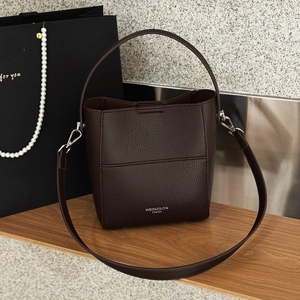 Detail der dunkelbraunen Eimer-Tasche aus genarbtem Leder mit silbernen Beschlägen