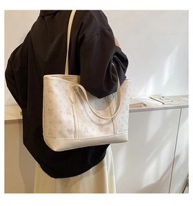 Detailed view of cream tote bag with cartoon prints shown on a model for daily styling