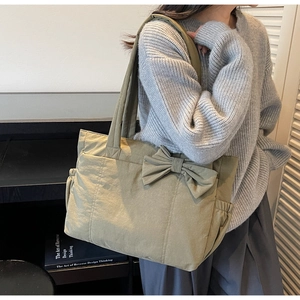 Détail du sac cabas en nylon vert olive avec grand nœud et poches latérales élastiques