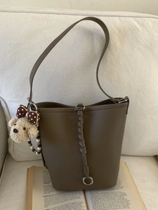 Borsa a secchiello in pelle marrone con ciondolo intrecciato e cane di peluche