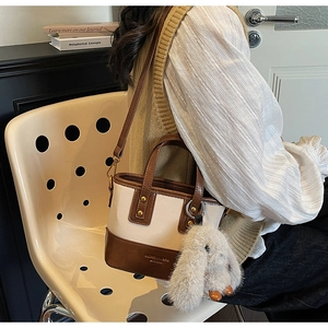 Détail du sac seau bicolore avec bandoulière et breloque lapin en peluche doux