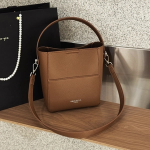 Detailansicht der braunen Leder-Eimertasche mit Litschi-Muster und Silberbeschlägen