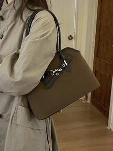 Retro brown canvas tote bag with leather straps and metal buckle shown on a model