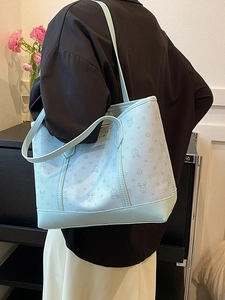 Light blue large tote bag with cartoon rabbit print worn by a model in a casual setting