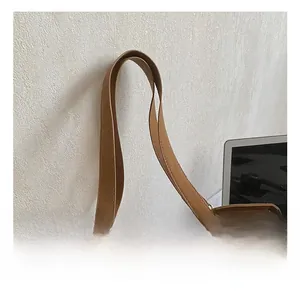 Close-up of wide leather strap and metal D-ring attachment on brown large tote bag