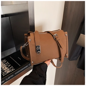 Detail of brown litchi pattern leather handbag with silver hardware and twist lock closure