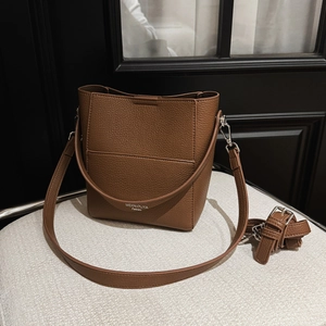 Detail der braunen Beuteltasche aus Leder mit Kieselprägung und silbernen Beschlägen