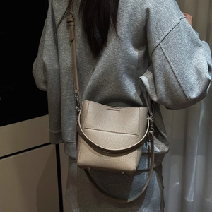 Nahaufnahme der beigen Beuteltasche mit litchi-geprägtem Leder und silbernen Beschlägen