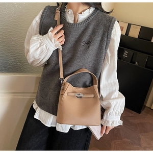 Detail of light brown lychee grain bucket bag featuring a silver metal twist lock closure
