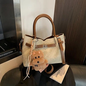 Detail of vintage beige and coffee tote bag with silver turn-lock and puppy charm
