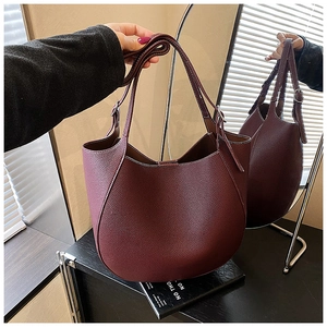 Dettaglio della borsa tote in pelle bordeaux con spalline regolabili e fibbie argentate