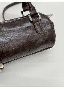 Detail of dark brown boston bag showing vintage wrinkled faux leather and silver hardware