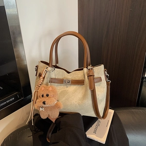 Macro shot of vintage tote bag with metal twist lock and cute plush dog pendant