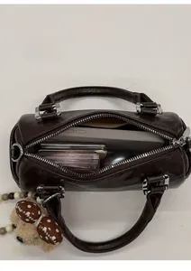 Top view of compact brown bowling bag showing interior capacity with makeup and phone