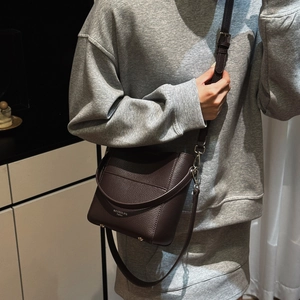 Detail der dunkelbraunen Eimer-Tasche aus Leder mit Lychee-Narbung und silberner Hardware