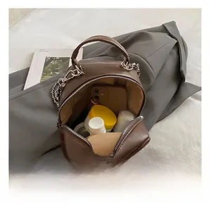 Interior view of brown quilted leather bag showing space for phone and cosmetics