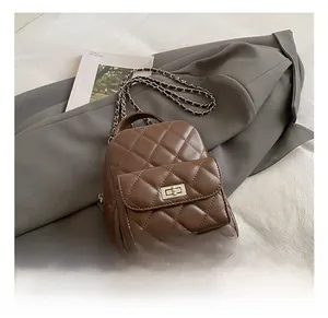 Detail of brown quilted mini backpack with leather chain strap and metal turn-lock