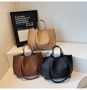 Three large tote bags in black, dark brown, and khaki with double handles and rivets