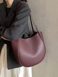 Borsa sottobraccio bordeaux minimalista in pelle martellata indossata da modella
