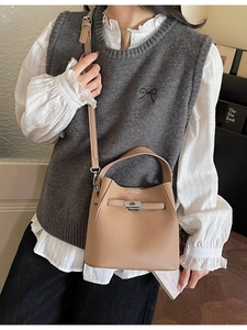 Elegant khaki lychee grain leather bucket handbag with metal clasp and shoulder strap