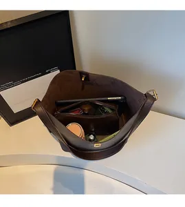 Spacious interior of dark brown suede tote bag with removable inner pouch and daily items
