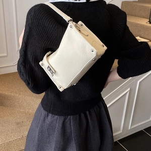 Detail of creamy white lychee leather bag with silver rivets and metal hardware details