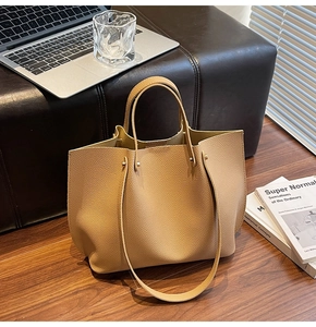 Detail of camel leather tote bag showing pleated texture and spacious interior capacity