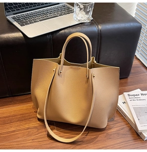 Close-up of pebble leather texture and metal rivets on light brown tote bag
