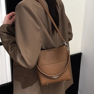 Braune Eimertasche aus Leder mit Lychee-Muster, Seitendetail und langem Schultergurt