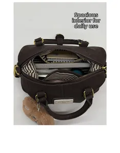 Detail view of large interior capacity for Boston bag with striped lining and accessories