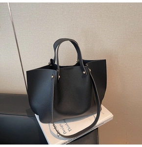 Detailed view of black lychee texture leather tote bag with gold metal rivet hardware