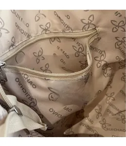 Detail view of large tote bag inner lining with zipper pocket and embroidered logo