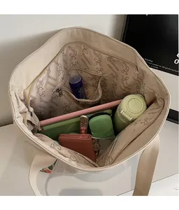 Top view of spacious interior of cream tote bag with zip pocket and patterned lining