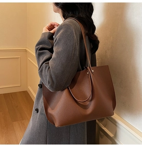 Detailed texture of dark brown lychee grain leather tote bag worn on shoulder