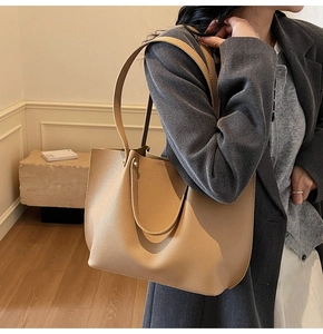 Close-up of khaki leather tote bag with lychee grain texture and minimalist slim straps