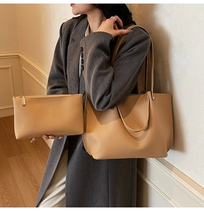 Detailed view of camel pleated tote bag and matching pouch with lychee leather texture
