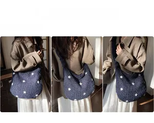 Grande borsa tote in peluche blu navy con stelle bianche indossata da una modella