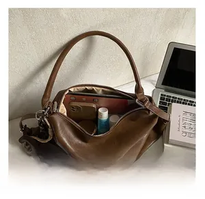 Vue intérieure d'un grand sac croissant marron foncé montrant sa capacité de rangement