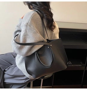 Detail of black lychee grain leather tote bag worn by model for daily commuting style