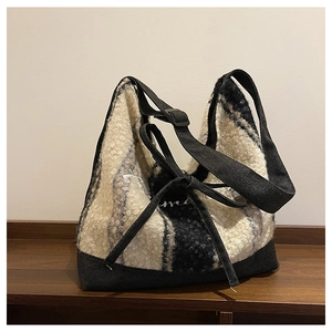 Dettaglio della borsa tote in lana a righe bianche e nere con ricamo Amour e fiocco