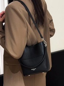 Minimalistische schwarze Beuteltasche aus Leder mit silbernem Logo und zwei Trageriemen