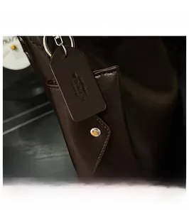 Vue détaillée de l'étiquette en cuir marron foncé avec anneau métallique sur un cabas