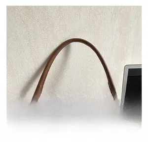 Détail du sac à bandoulière en cuir marron avec une poignée confortable et une fermeture éclair argentée