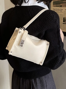 Retro cream white leather boston bag with silver studs worn by a model in back view