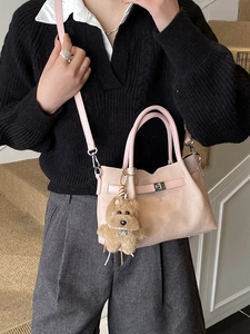 Pink matte leather tote bag with silver lock and plush dog pendant on a model