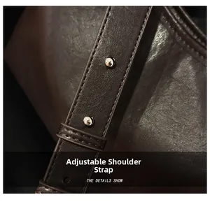 Gros plan sur la bandoulière réglable en cuir avec boucle argentée du sac cabas marron
